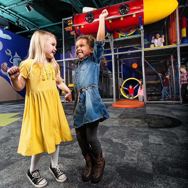 Two girls jumping in Inagination destination