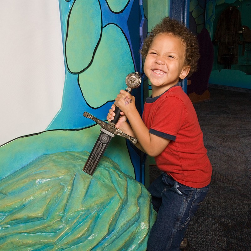Boy pulling sword in stone