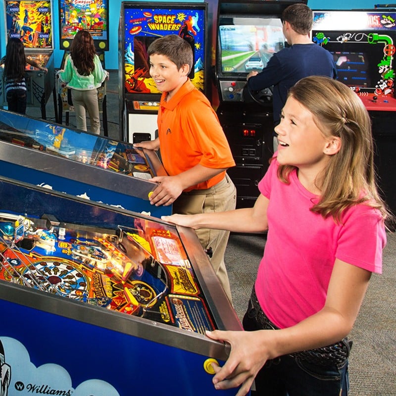 Kids playing pinball closeup
