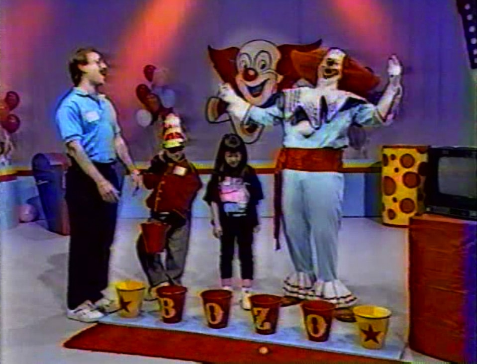 Still from The Bozo Show, 1990, courtesy of Lauren Sodano. The ball bounced out of the bucket! Nice try, Dad.