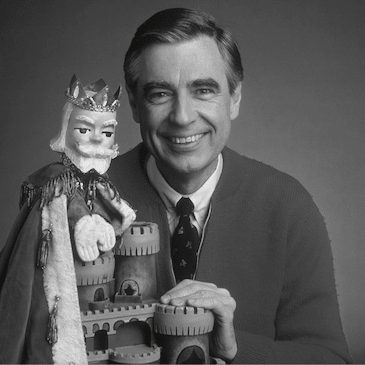 Portrait photo of Fred Rogers holding a puppet of a king.