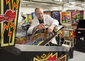 Arcade Game Conservation Technician, Martin Reinhardt, working on a pinball machine.