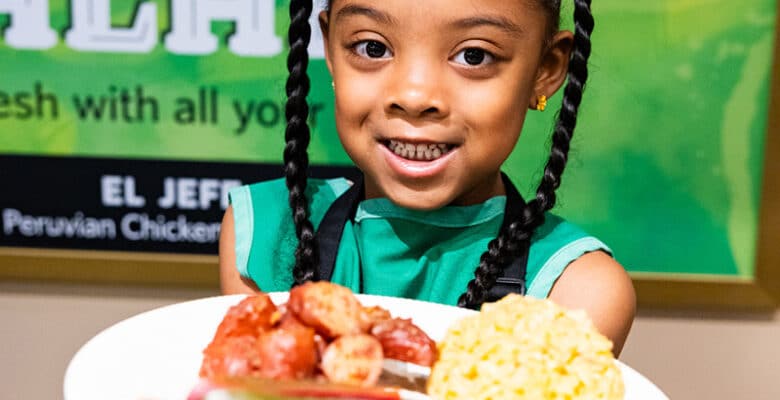 Young girl with plate of food in Wegmans super kids market