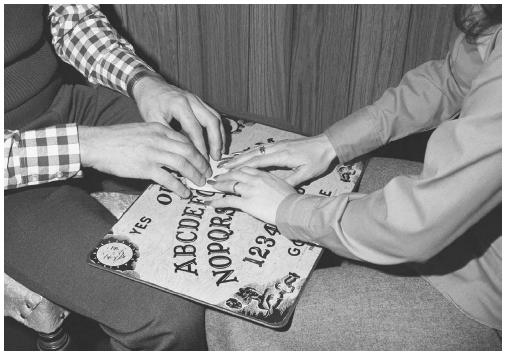 Typical position for playing with Ouija. Also note that a male and a female are playing.