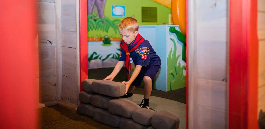 Boy scout building wall in Berenstain bears exhibit