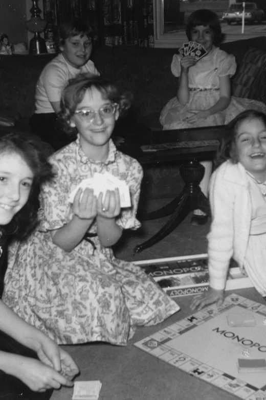 Black and white photo of girls playing monopoly