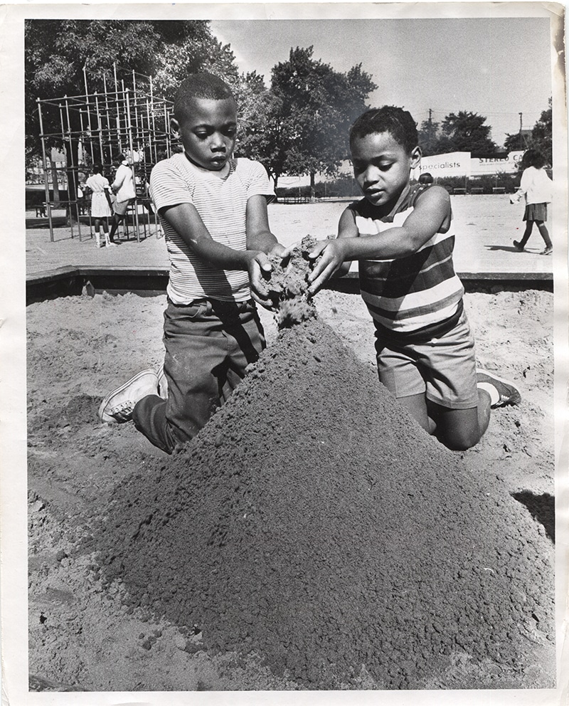 Black and white photo of 2 boys playing in sand