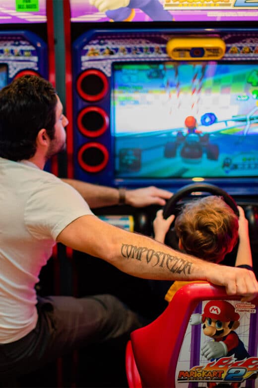 Father and son playing Mario Kart in Raceway Arcade