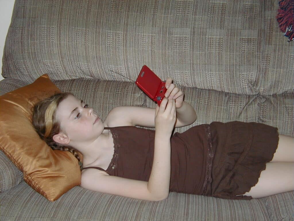 Picture of Young girl plays on a red Game Boy Advance SP, 2006, gift of Kristy Allen Hisert. The Strong National Museum of Play, Rochester, New York.