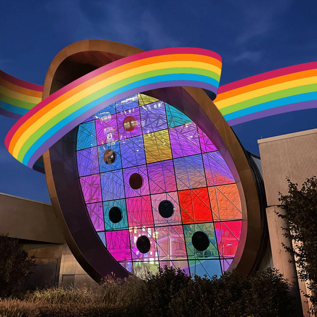 Colored glass window of the Adams Atrium surrounded by a rainbow ribbon.