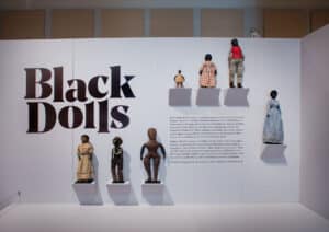 Black Dolls exhibit, logo with dolls on wall