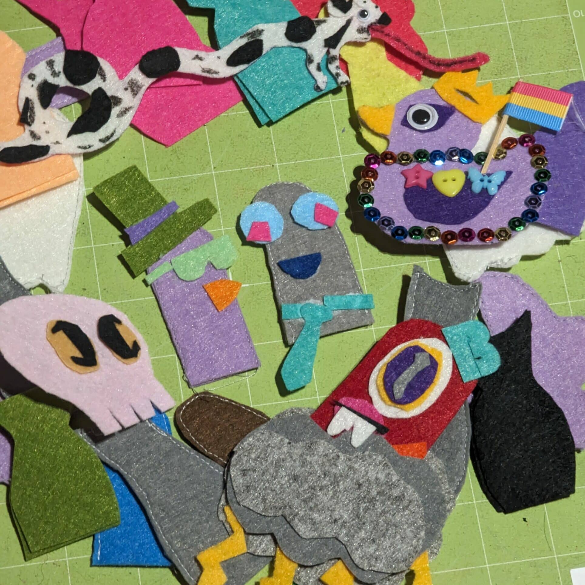 Many felt finger puppets on a crafting board