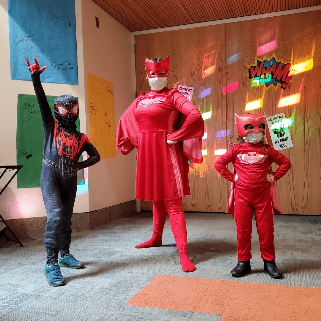 A Woman and two children dressed in PJ Superhero costumes