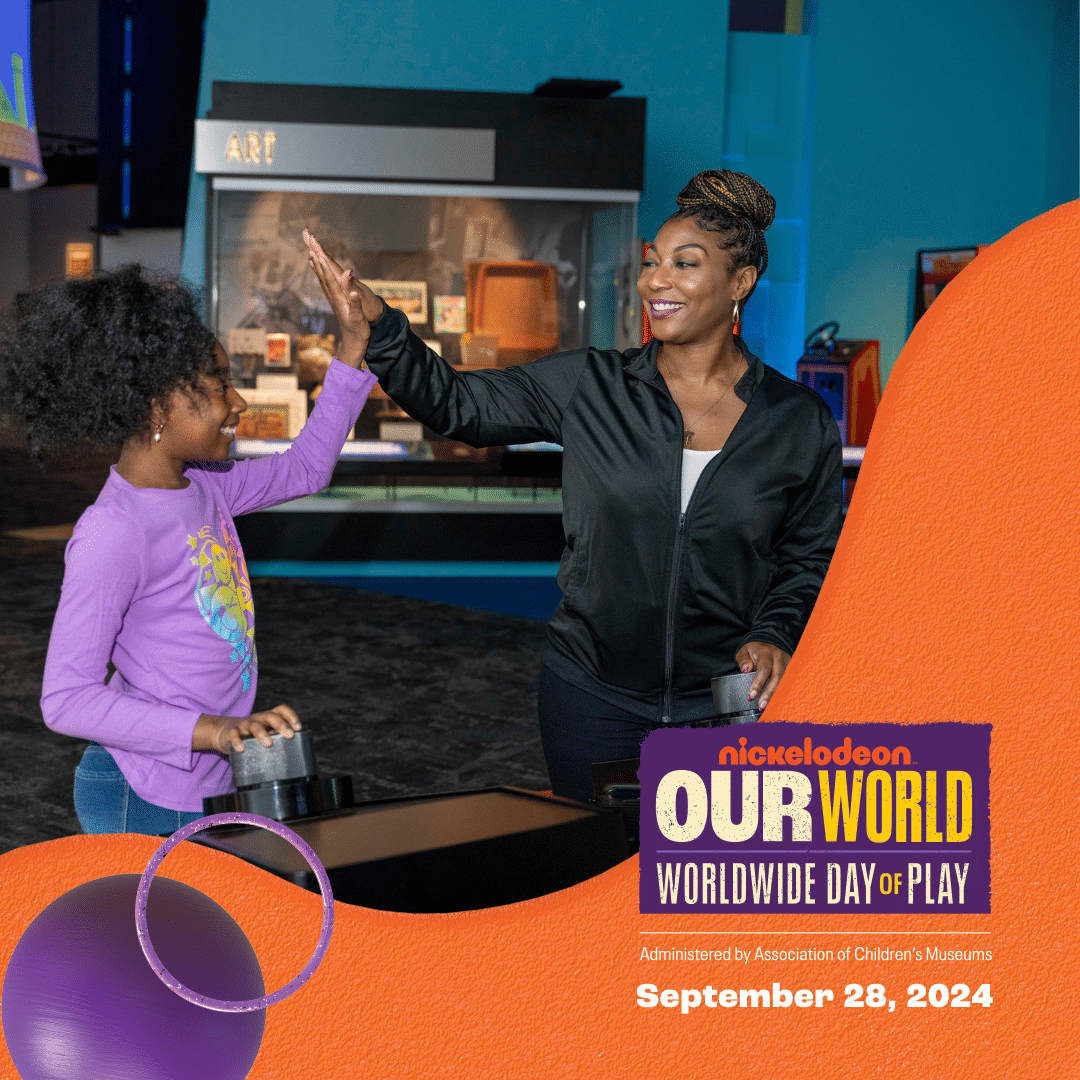 Mother and daughter high-fiving while playing a video game at High Score