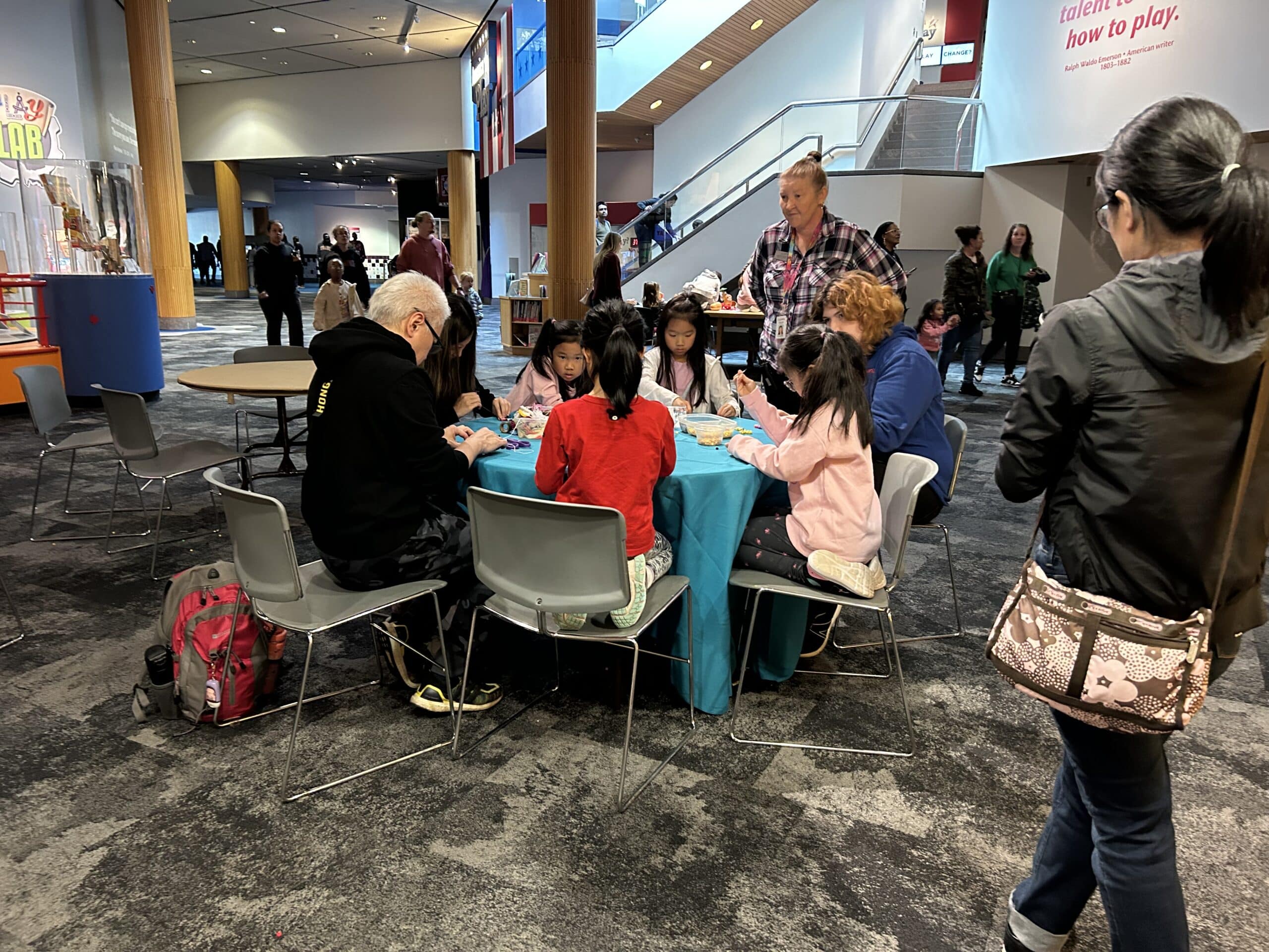Family doing crafts at a table outside Field of Play