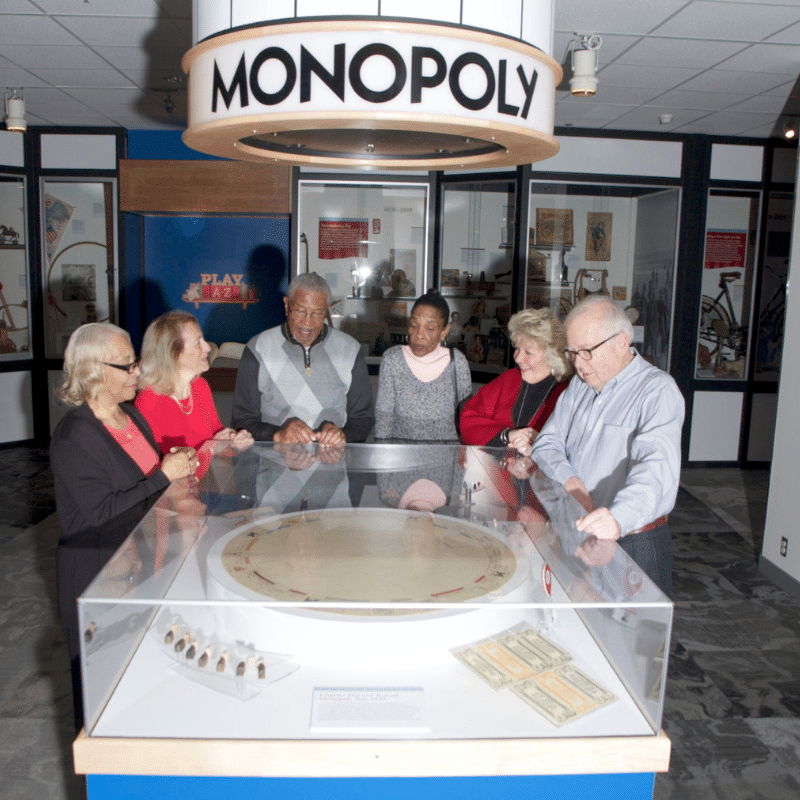 Group of seniors gathered around a Monopoly display