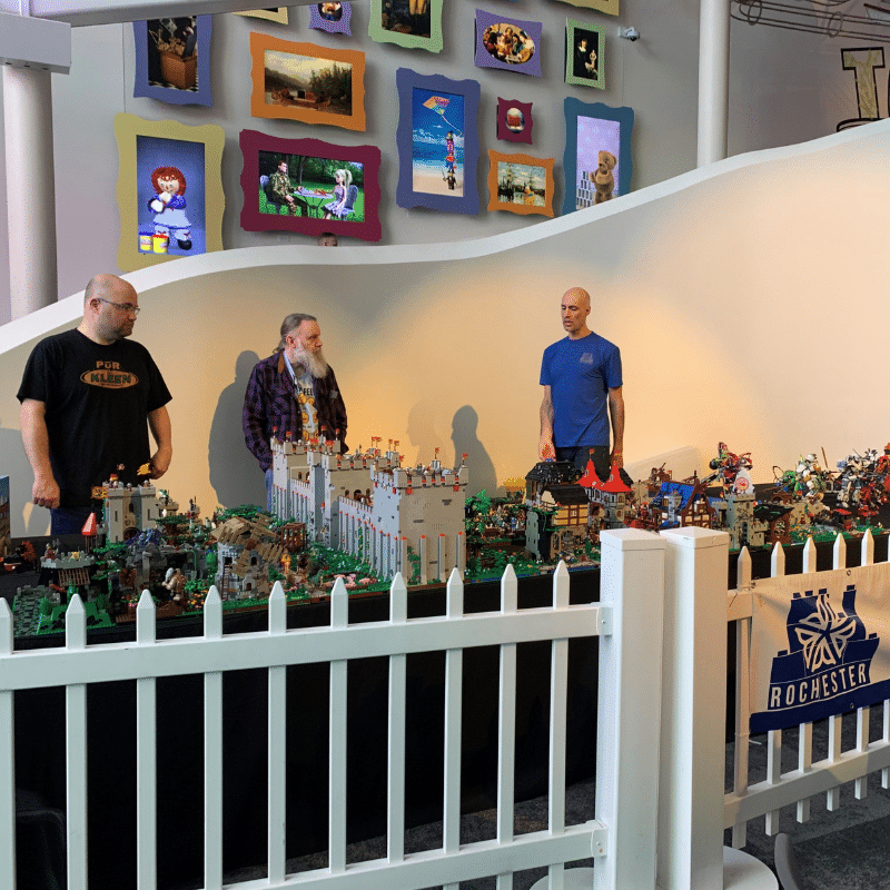Members of the Rochester Lego Users Group standing behind their LEGO creations