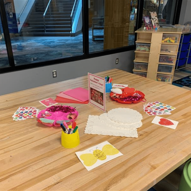 Craft table with Valentine's card supplies set up.