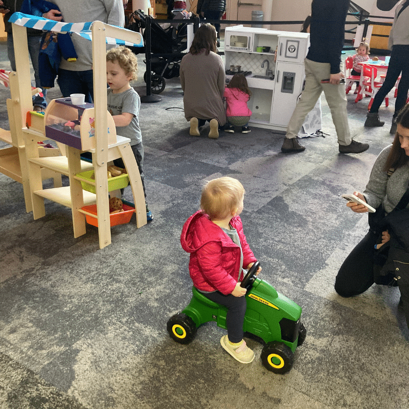 Girl playing in American Dairy Association's winter display in Adams Atrium