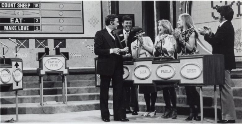 Set of Family Feud with host addressing family of five