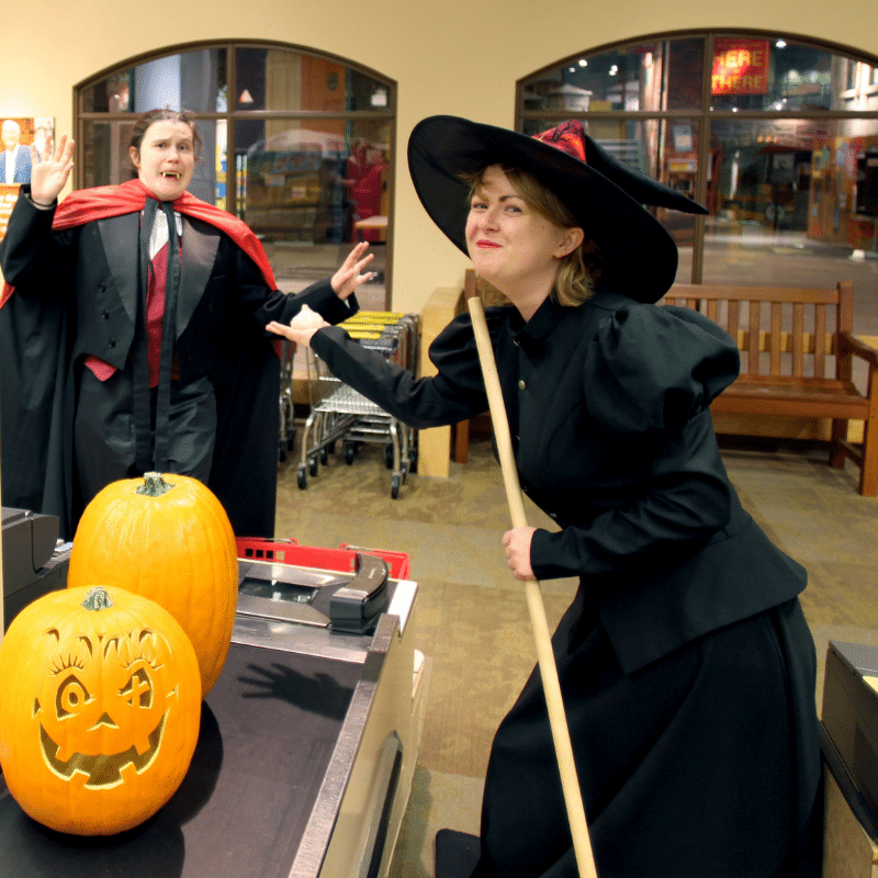 Two adults dressed as a witch and a vampire in Wegmans Super Kids Market