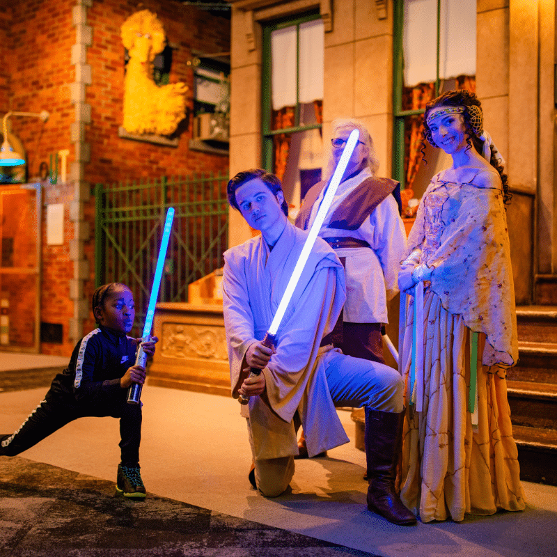 Young Guest posing with 501st Legion holding a blue lightsaber