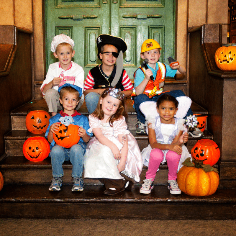 Group of kids in costumes sitting on the Sesame Street steps